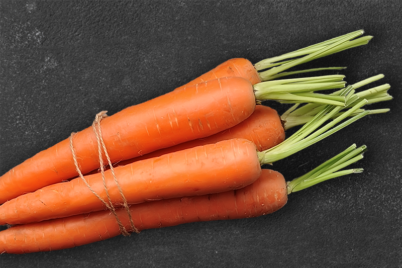 A few carrots placed on a black background